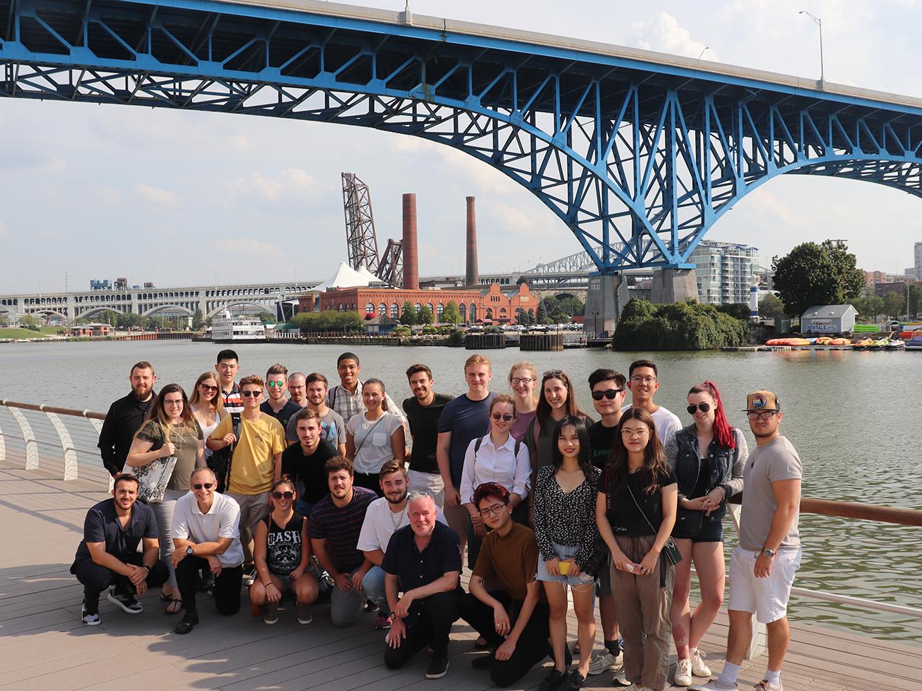 Group of students and faculty members pose under a bridge in Cleveland, Ohio.