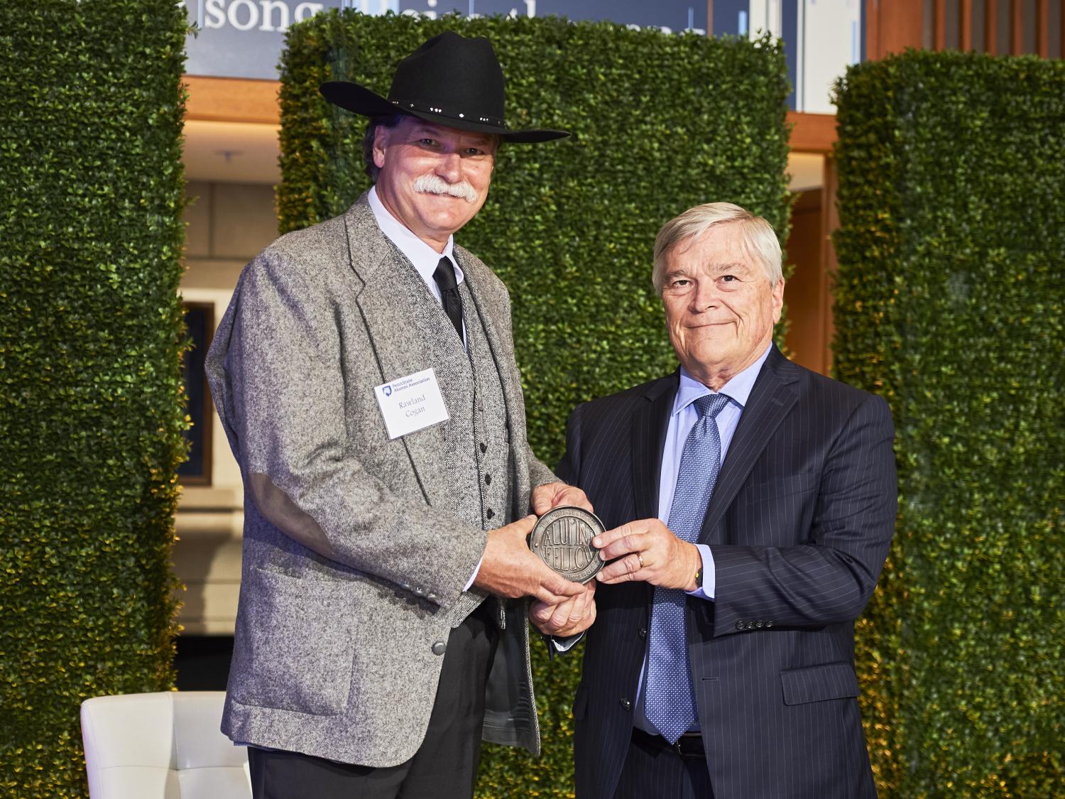 Rawland Cogan accepts his Alumni Fellow award from Penn State President Eric Barron.  
