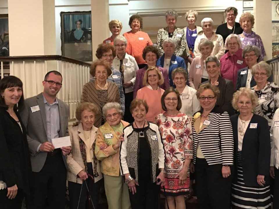 A large group of women and one man pose for a picture.
