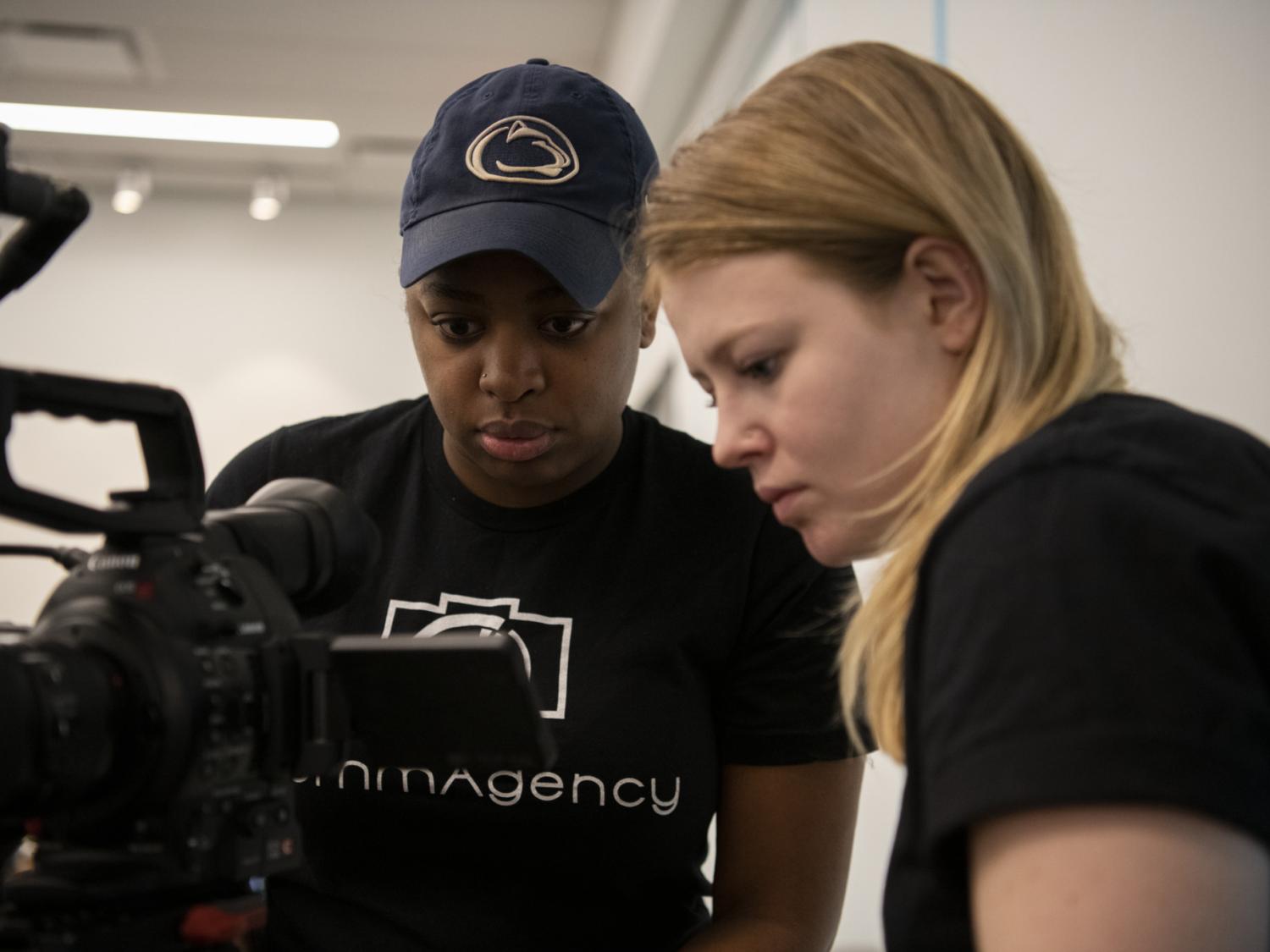 Students Imani Carter, left, and Callaway Turner set up a shot for a client. 
