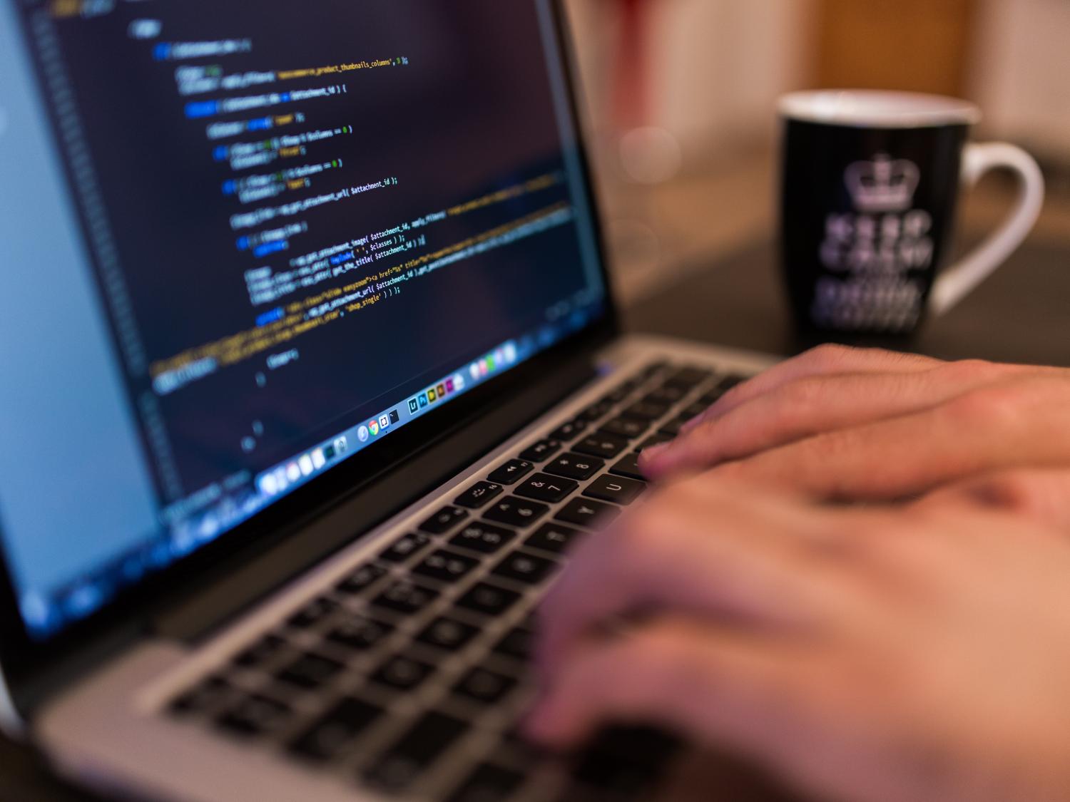 Close-up photo of hands typing on a laptop computer