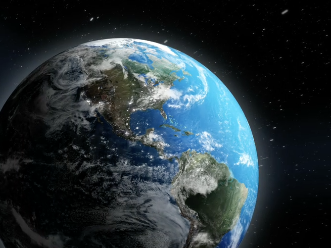 Image of Earth showing North and South America on a black background with faint white streak representing cosmic rays streaming toward the Pierre Auger Observatory in Argentina