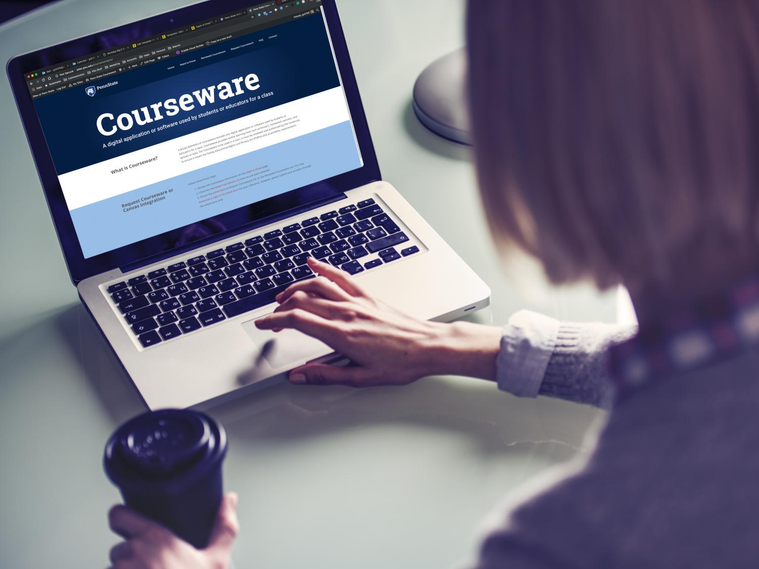 A person in front of a laptop browsing the Courseware website. 