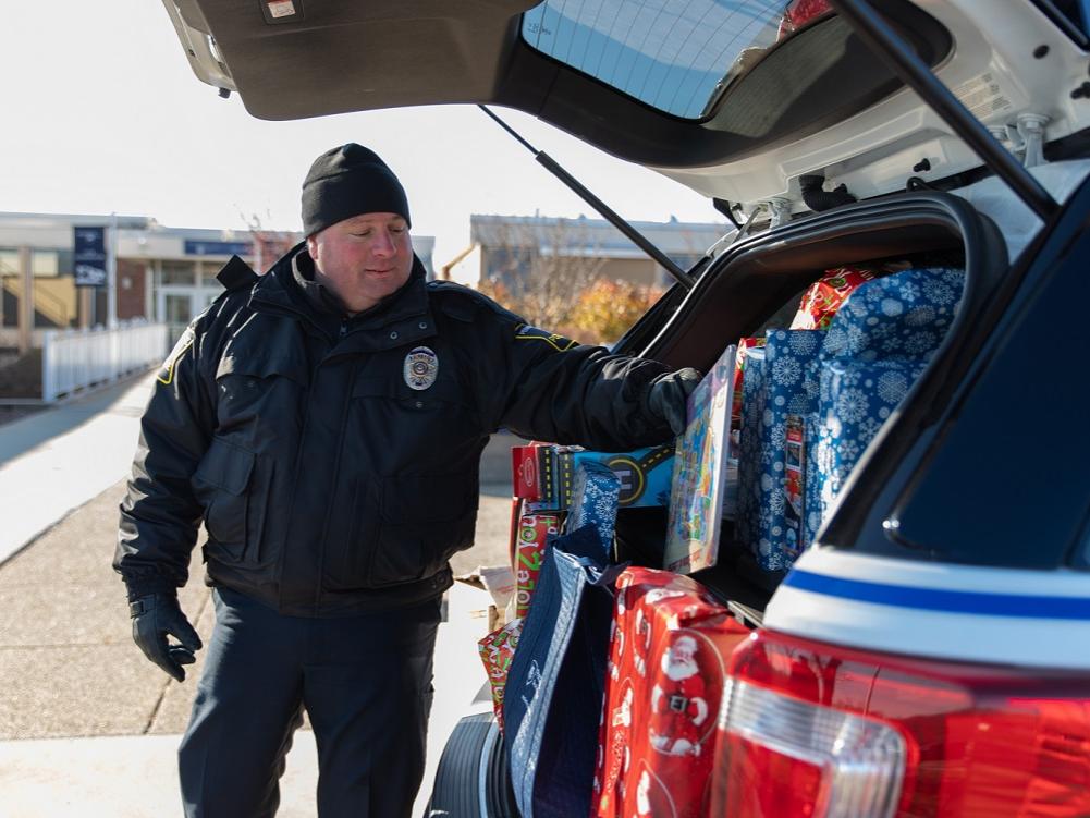 Police officer puts gift in car