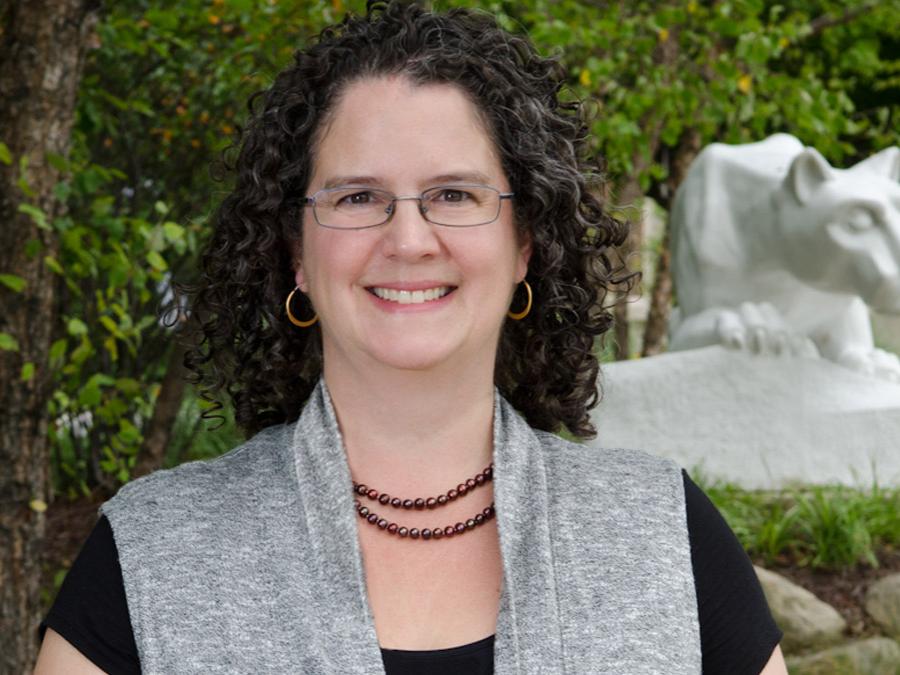 Beaver Chancellor Jenifer Cushman stands in front of the campus Lion Shrine.