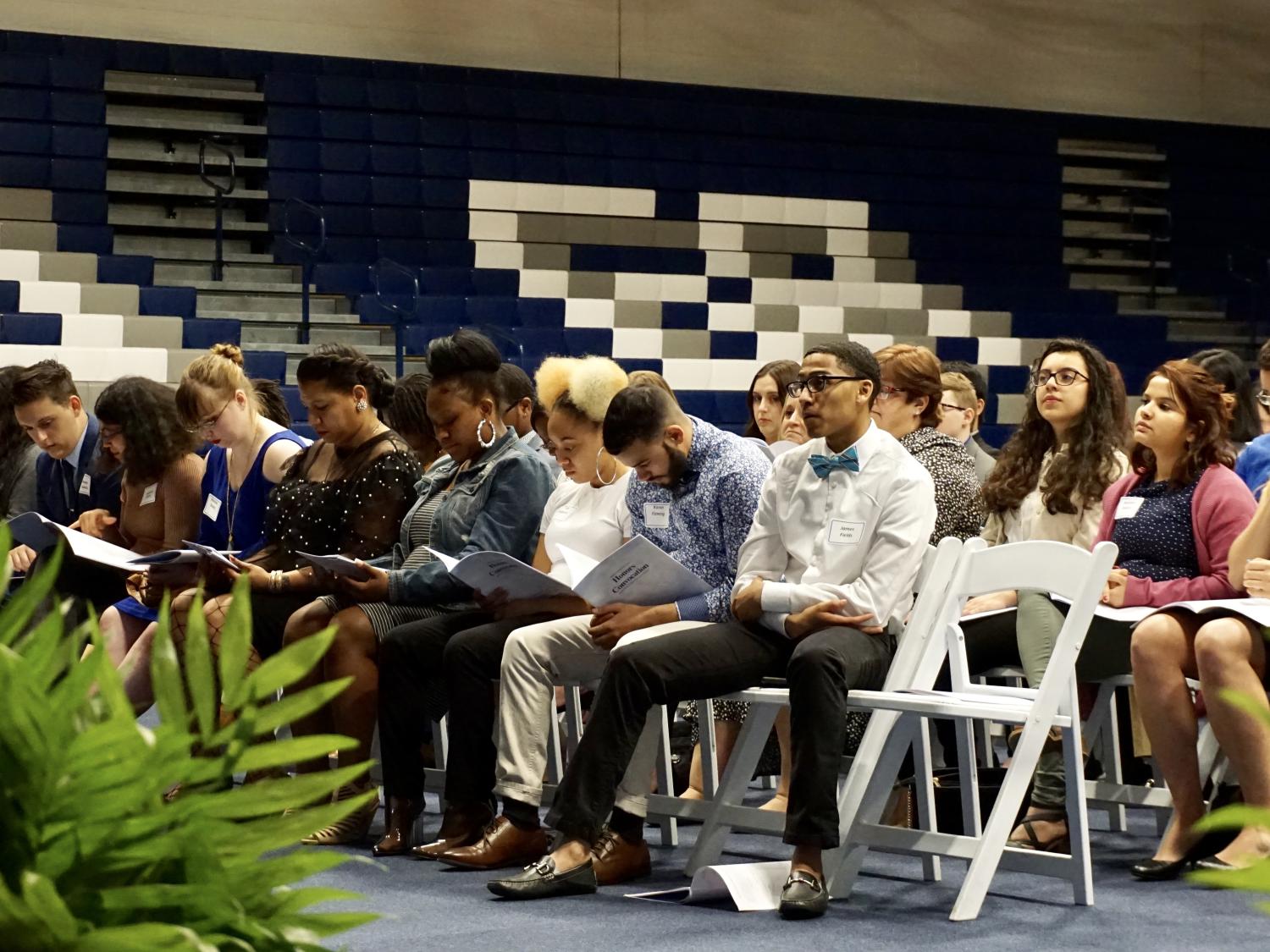 students sitting in chairs reading program