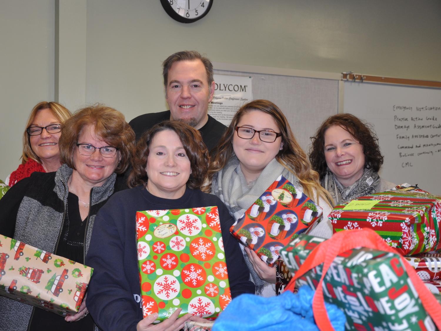 Staff members gather for a photo with wrapped gifts