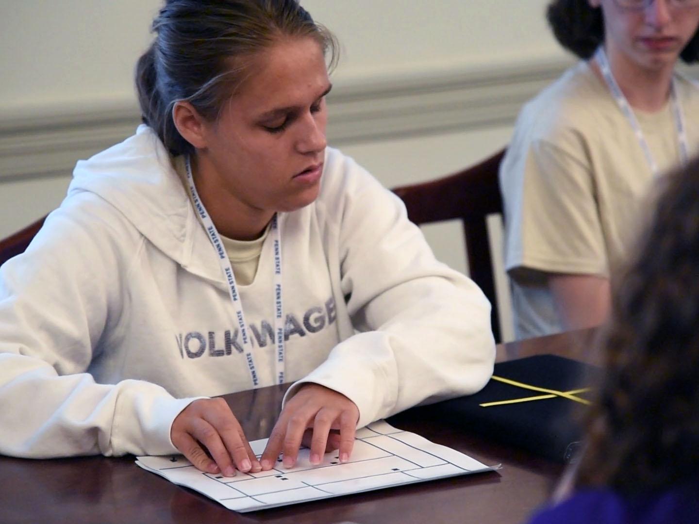 Student reading map with her fingers