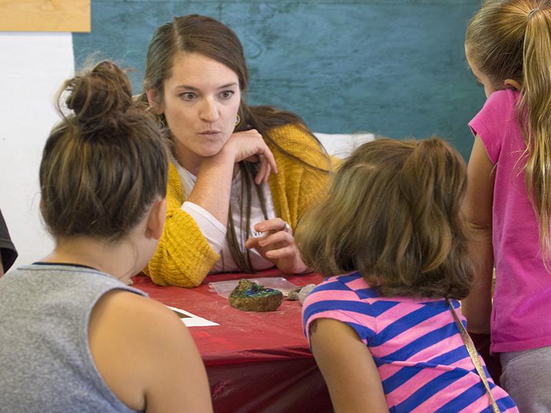 Virginia Marcon, a Ph.D. candidate in geosciences and co-president of the group WE ARE for Science, talks to children about the study of the Earth during the group's Ask a Scientist event recently at the Grange Fair.