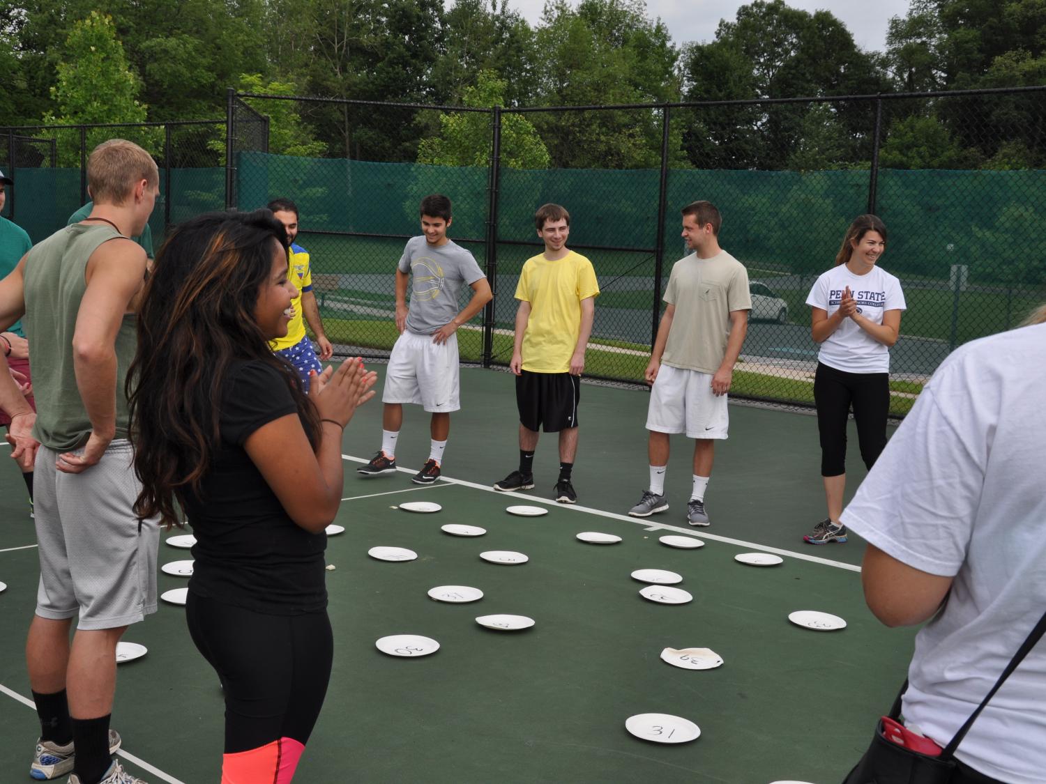Group of students stand in a circle while playing a game of hot lava