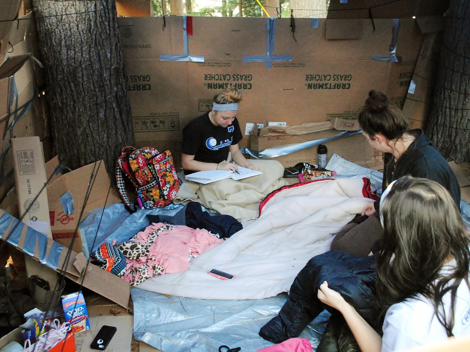 Students study in a cardboard shelter.