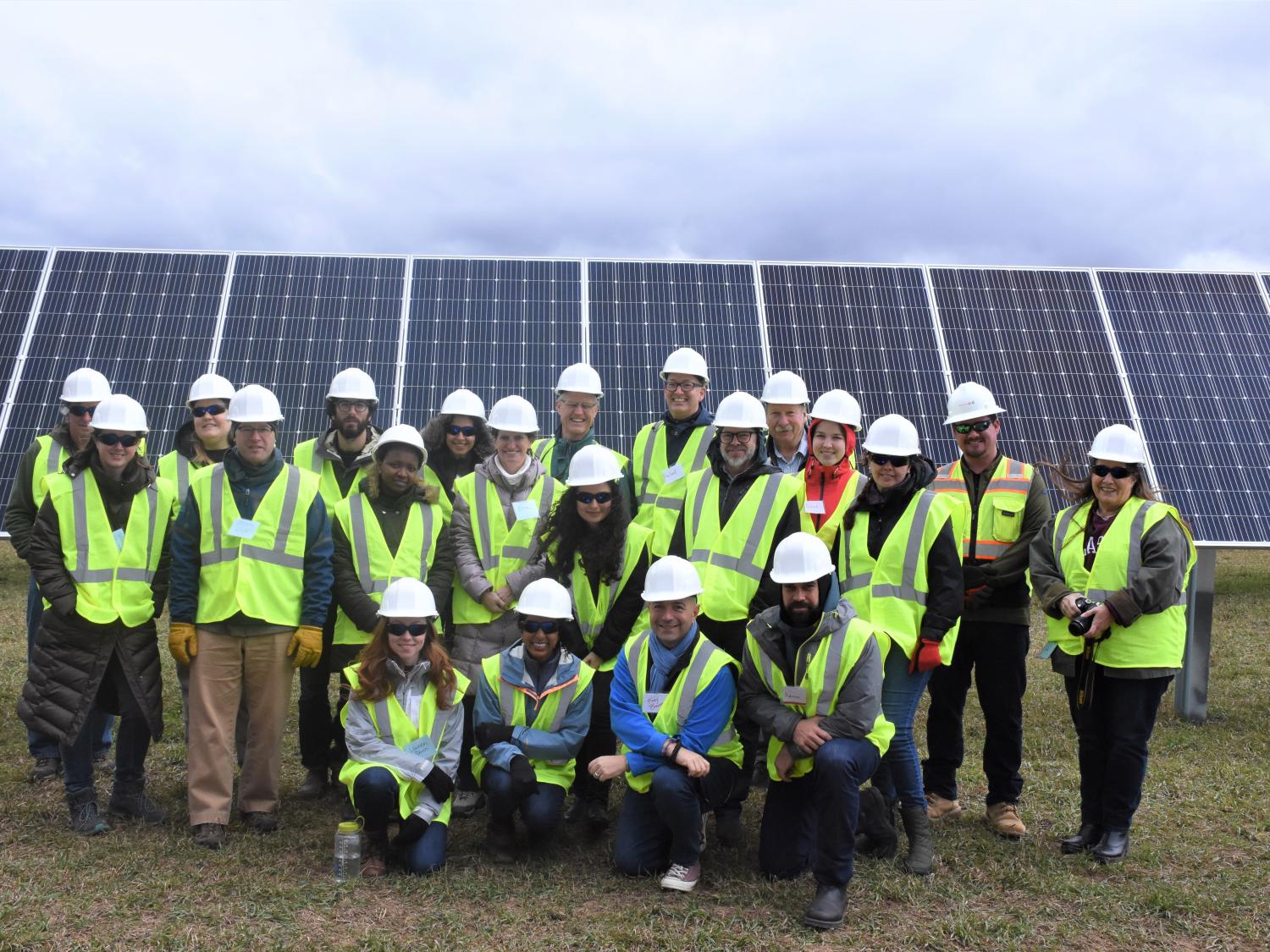 LandscapeU field trip participants pose in front of a solar array.