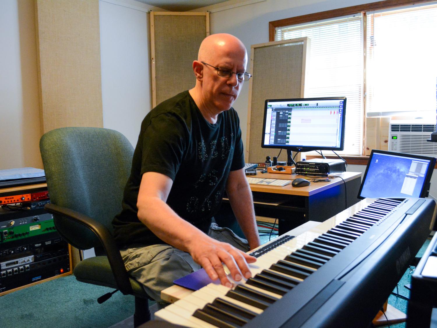 Bob Klotz plays keyboard in his studio.