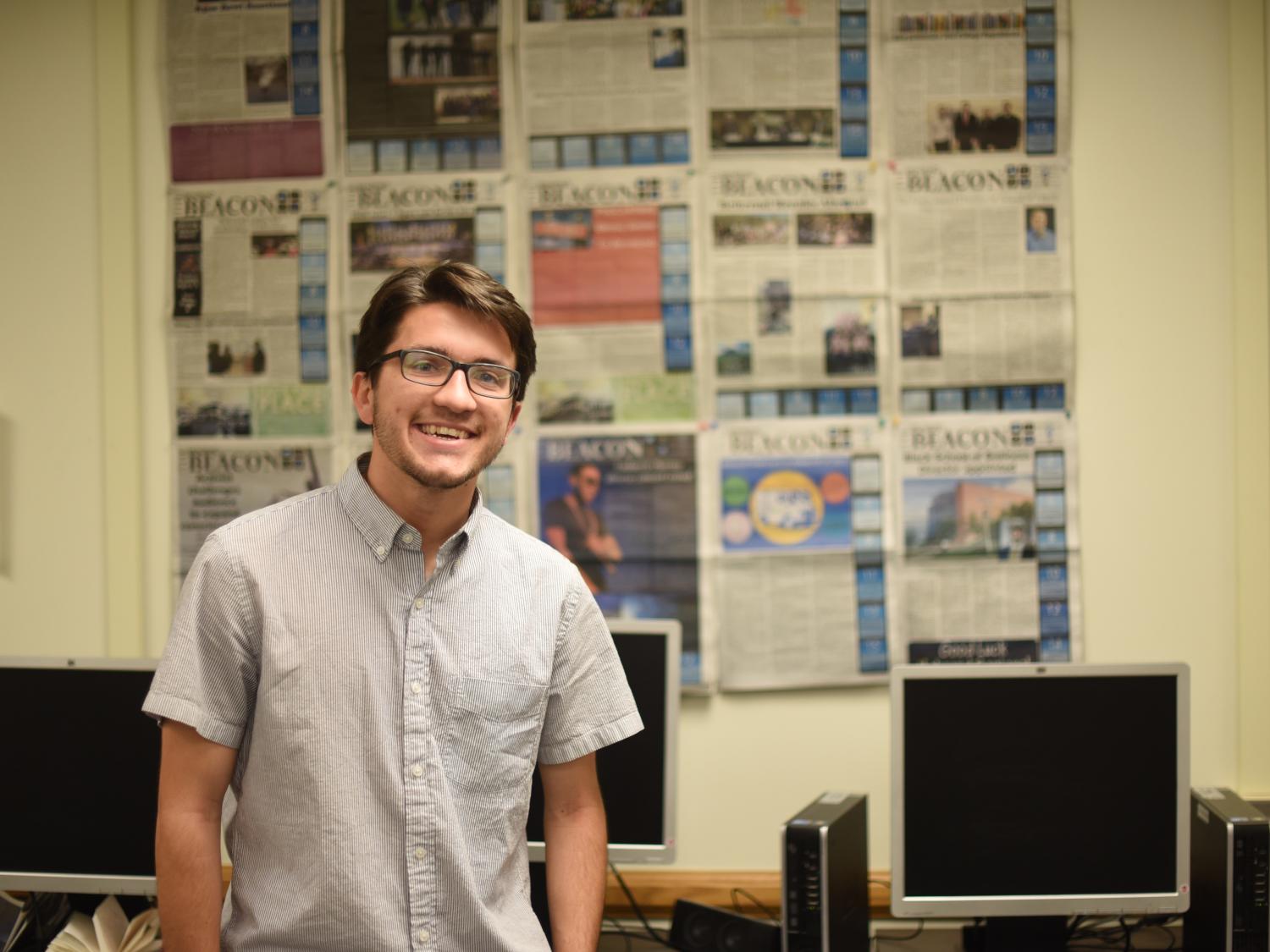 Josh Kolarac stands in front of a display of Behrend Beacon newspapers.