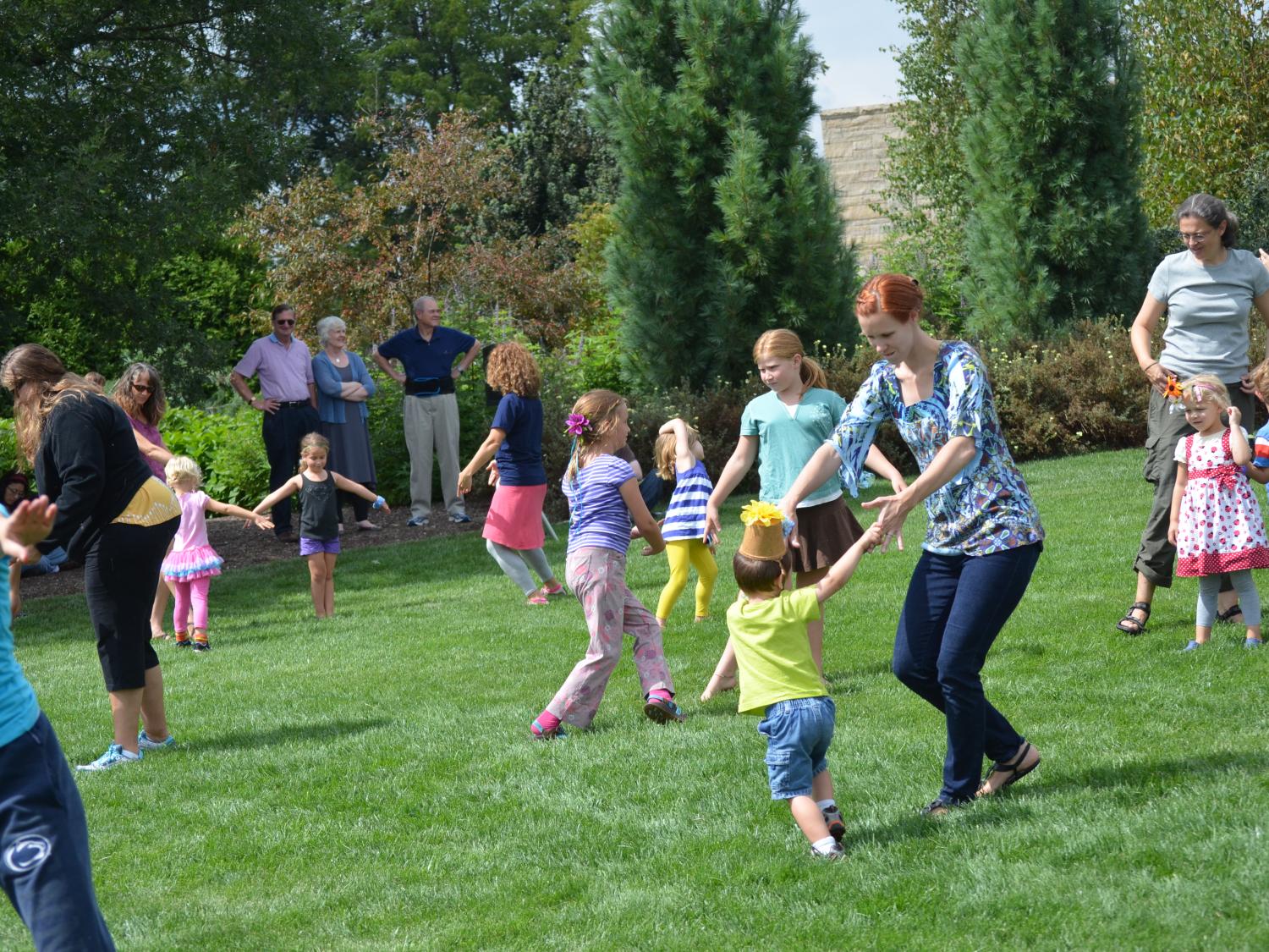 Parents and their children frolic on the lawn at The Arboretum at Penn State.