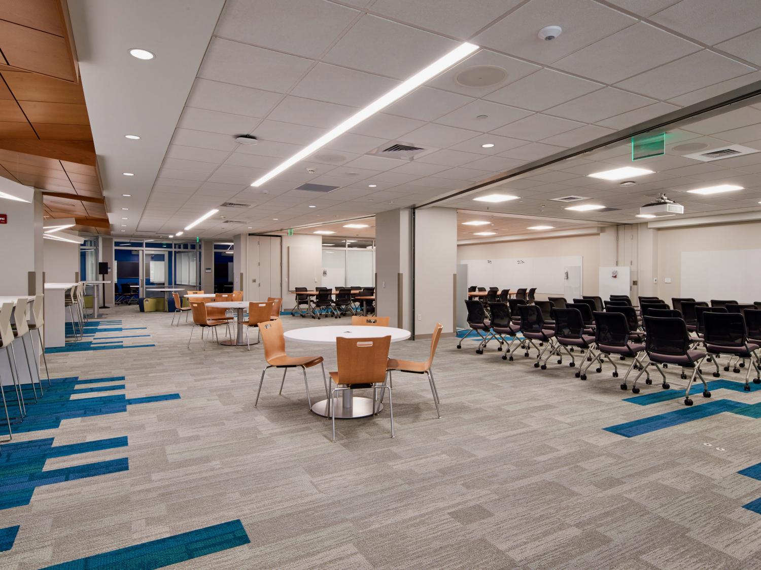 bright multipurpose room with whiteboards and work tables and chairs on wheels