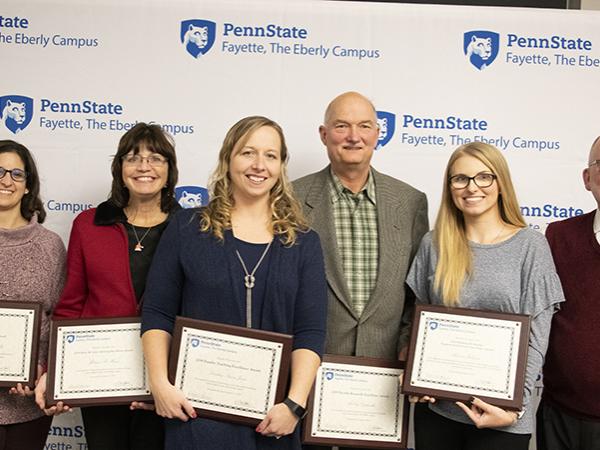 Mary Budinsky, Melissa Miner, Lindsey Simon-Jones, Andrzej Gapinski, and Rebecca Johnson accept 2019 excellence awards presented by Charles Patrick, chief academic officer and chancellor.