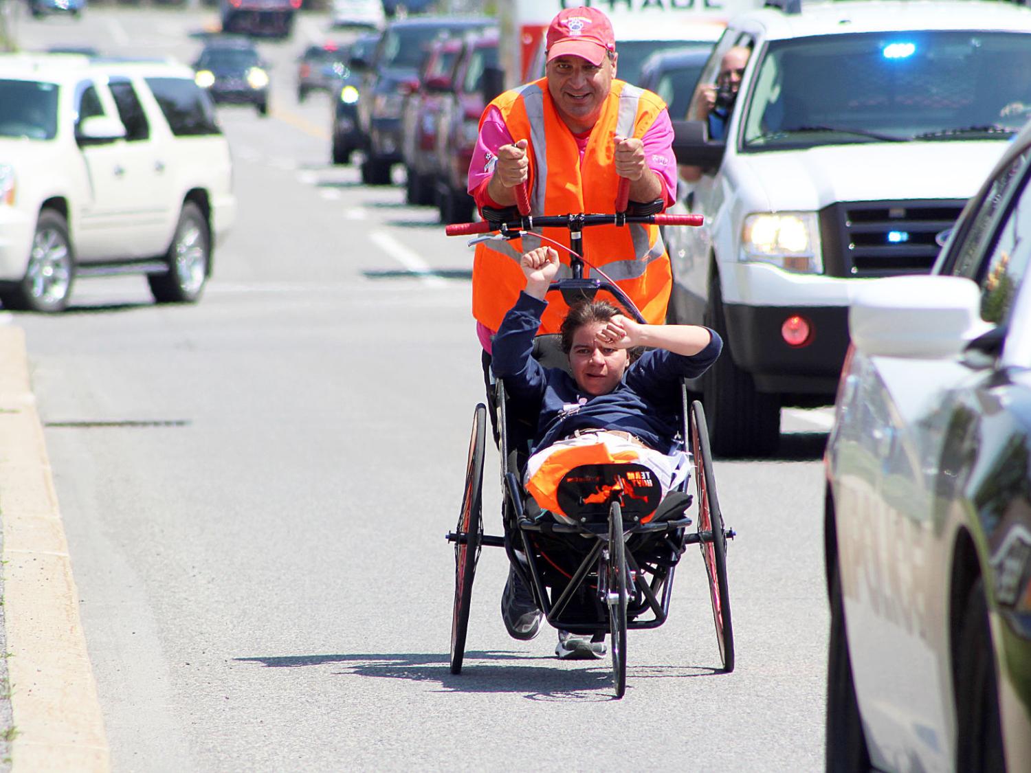 Dan Perritano pushes his daughter Emma in a wheelchair on a charity walk.