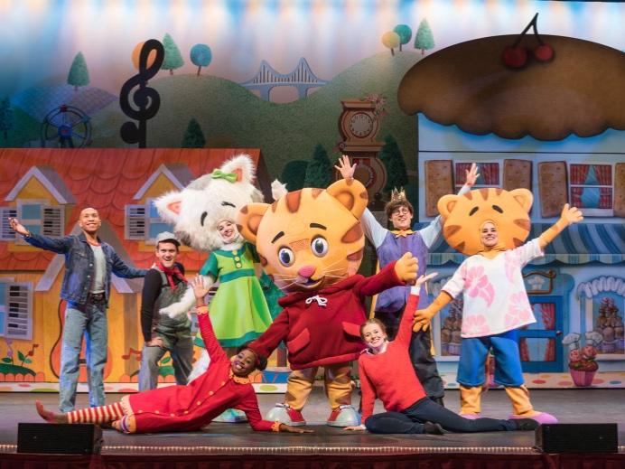 Daniel Tiger and his friends pose on stage for the camera.