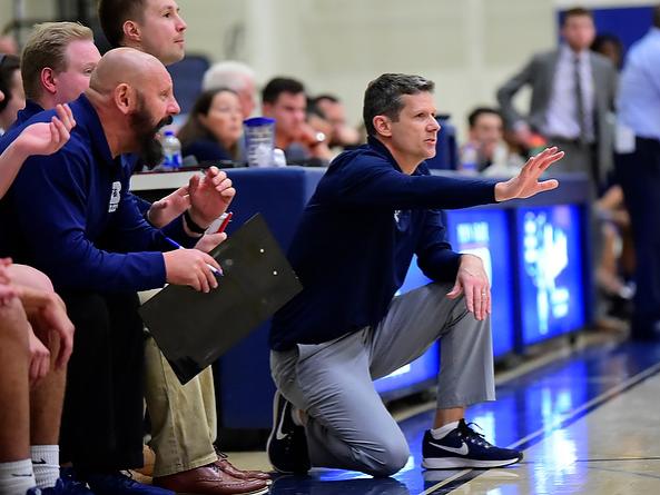 Penn State Behrend men's basketball coach Dave Niland gives instructions from the side of the court.