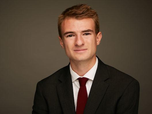 Young man smiling and wearing a jacket and tie