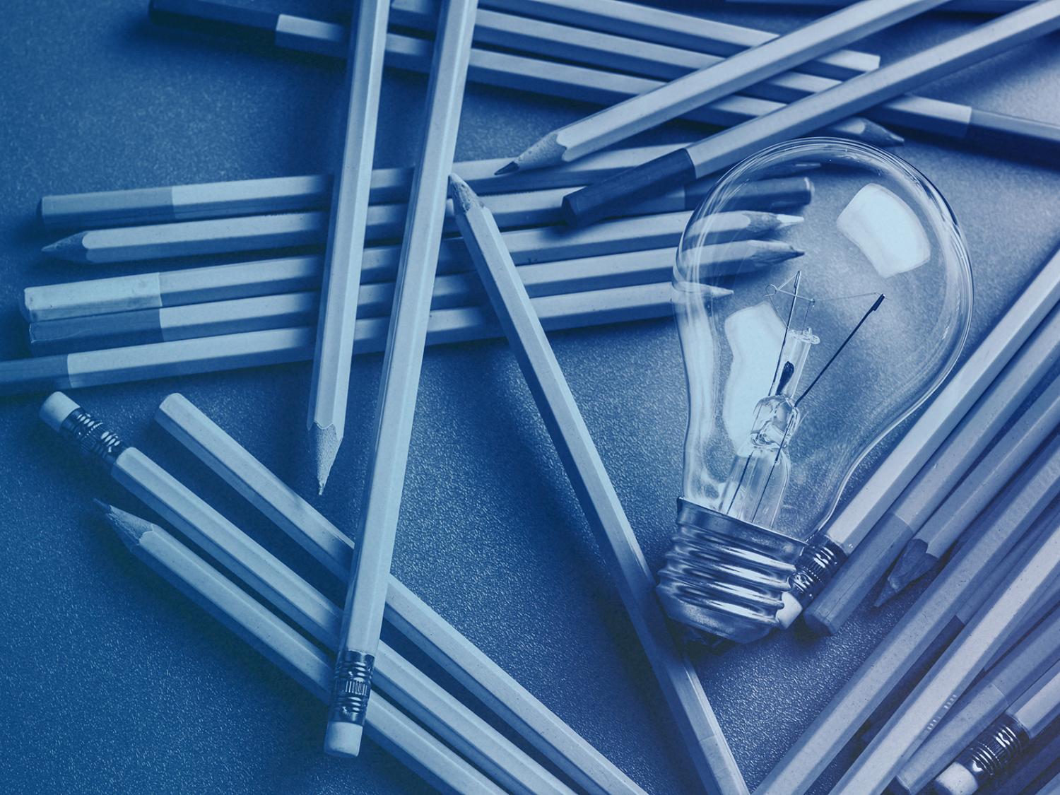 lightbulb with scattered pencils