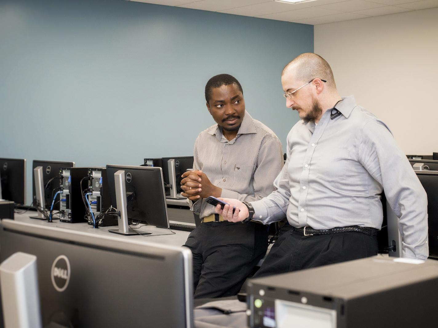 Beaver Professor Richard Lomotey and IST student Joe Pry confer in a computer lab.