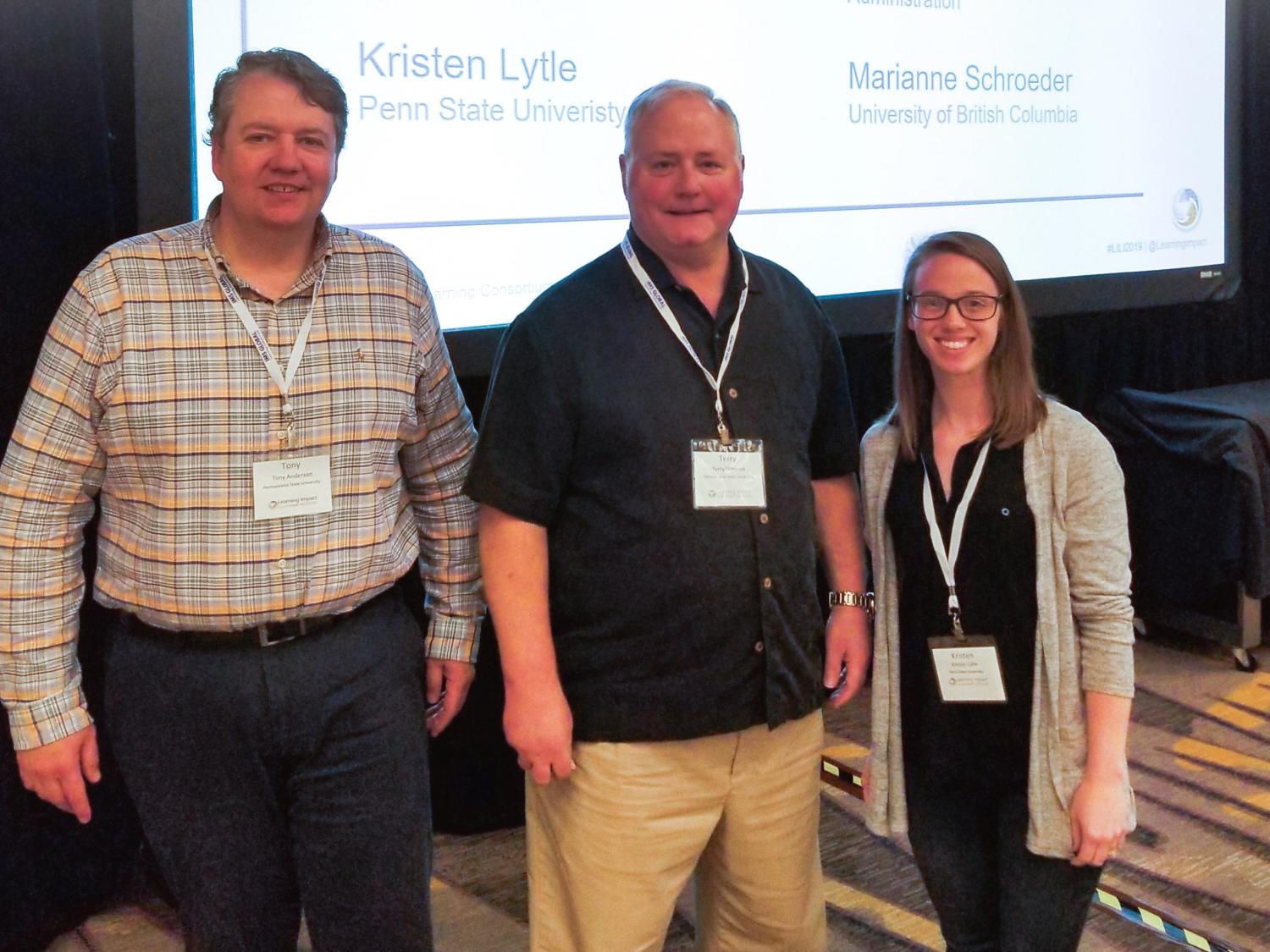Penn State TLT Operations Team Award winners standing in front of a screen 
