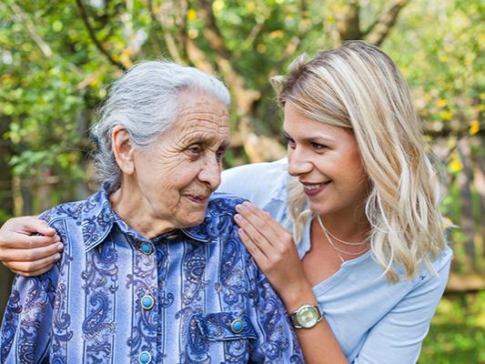 Elderly female with young lady touching shoulder