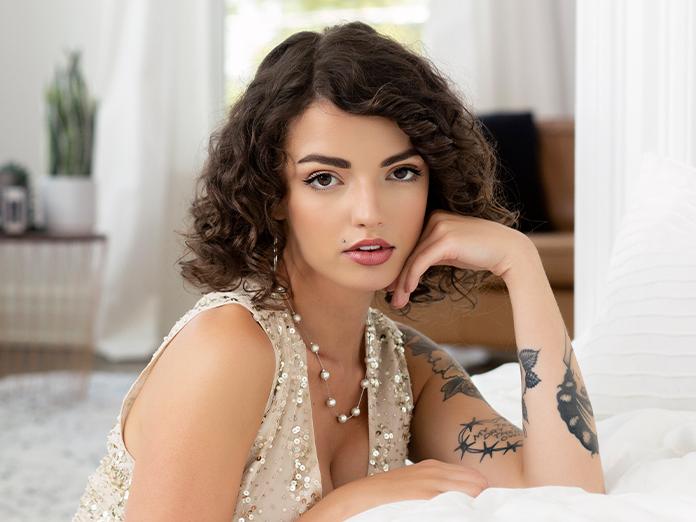 A woman rests her hand against her cheek.