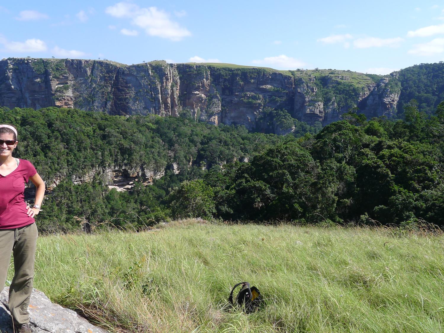 woman standing in grasslands in Africa with mountains in the background