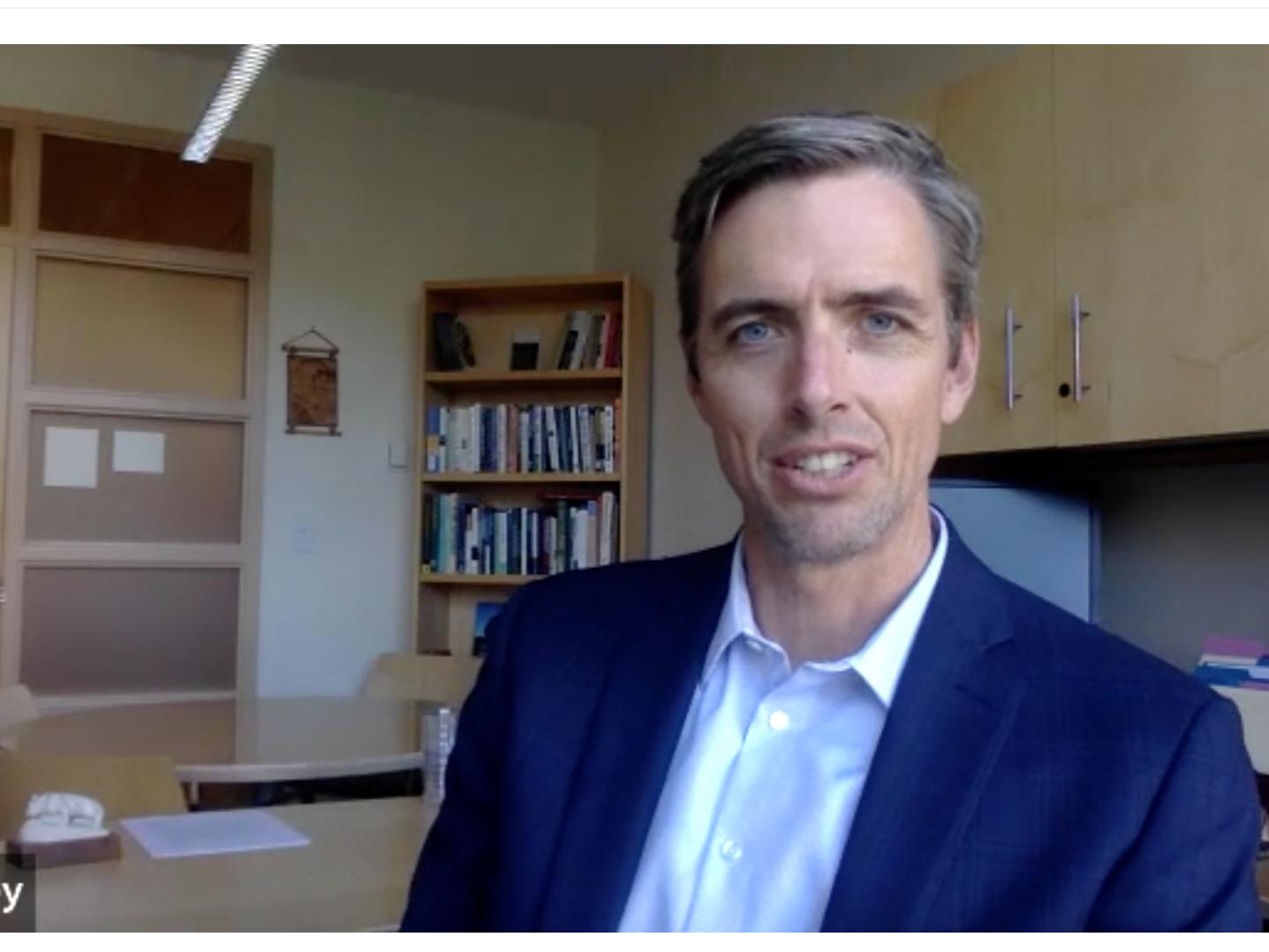 A screenshot of Erik Foley speaking in a video 