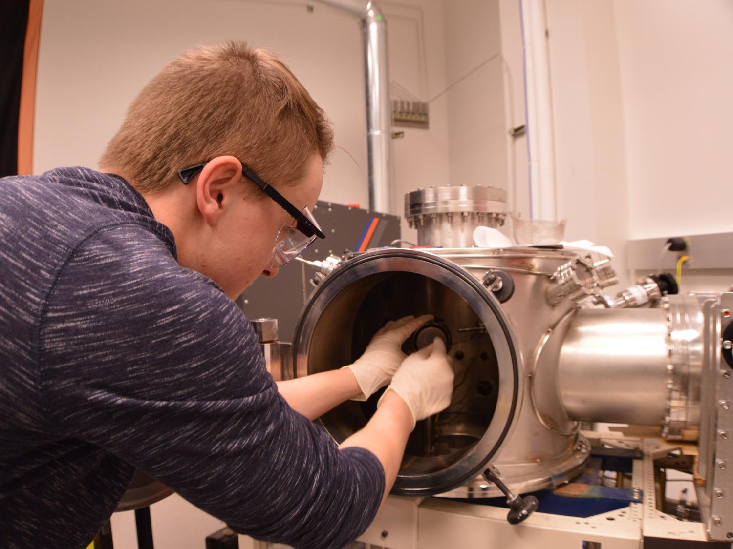 Evan McHale uses laser deposition machine to conduct research at the millennium science complex