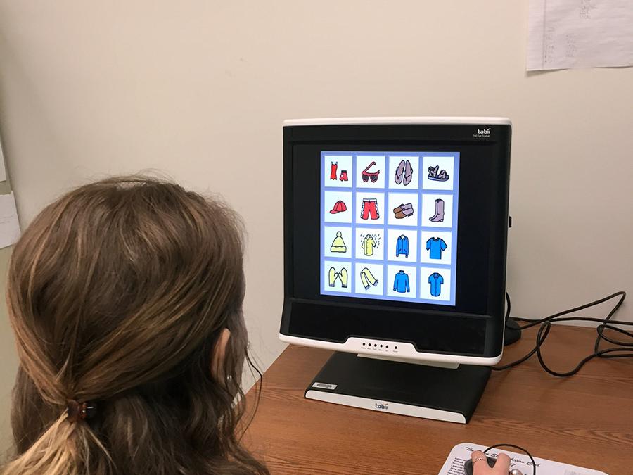 A Penn State graduate student demonstrates an eye tracking test on an aided augmentative and alternative communication (AAC) display.
