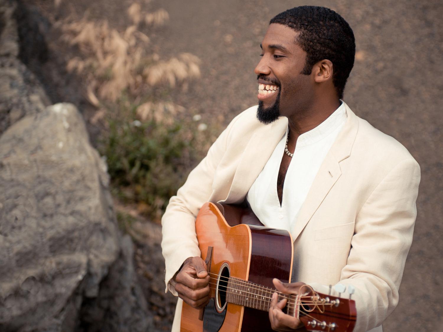 Eric Ian Farmer playing guitar in white jacket