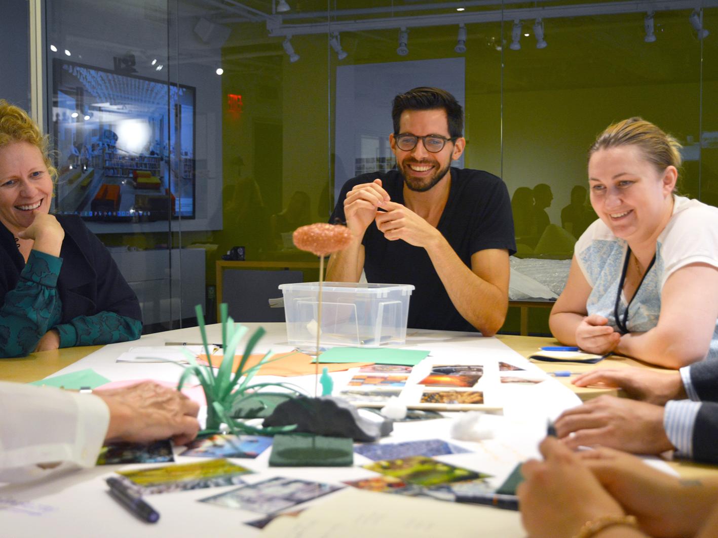 Adam Longenbach, center, interacts with coworkers at a design workshop.