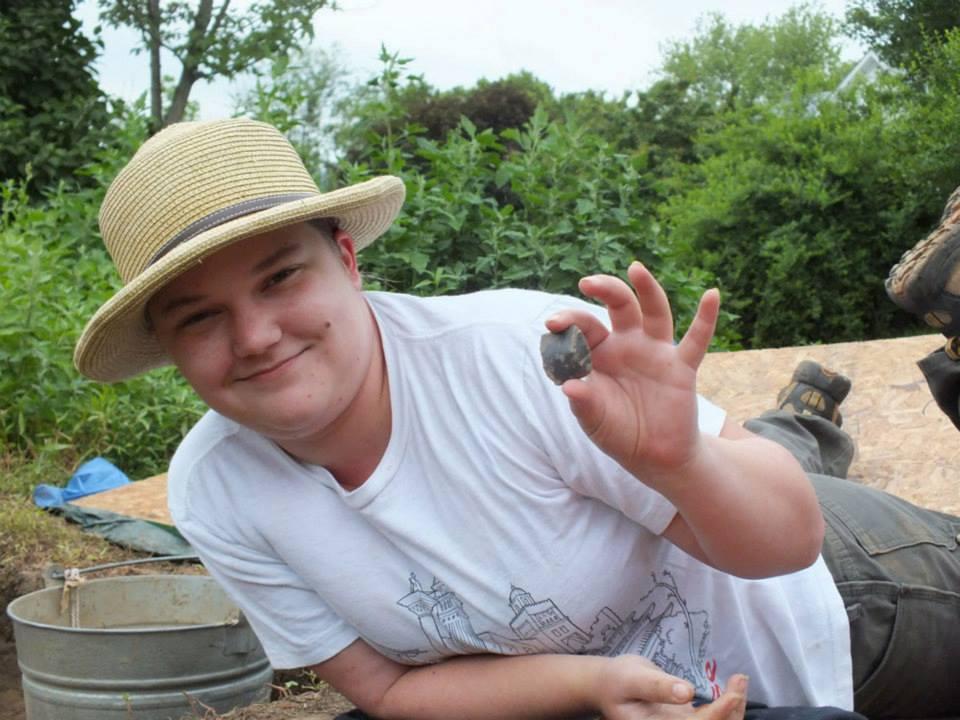 Penn State anthropology student digs up a British gun flint during this summer's Archaeological Field School.