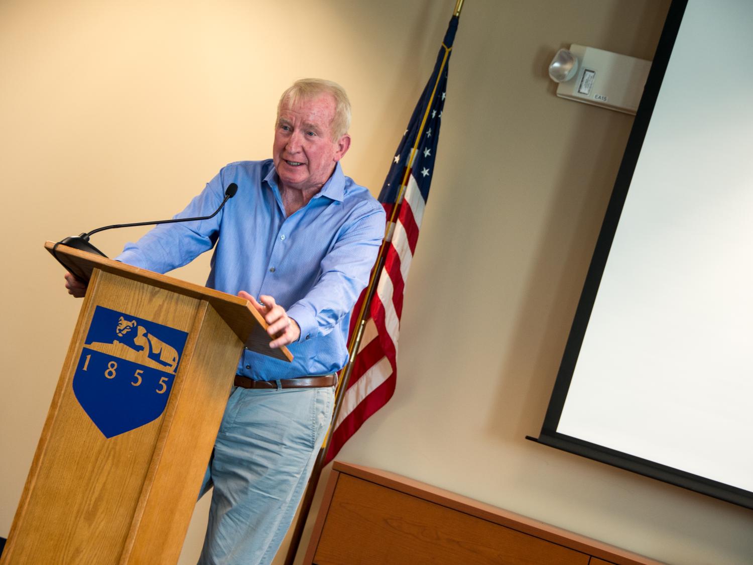 Adjunct Professor speaks from behind a podium on Veterans Day 2014.