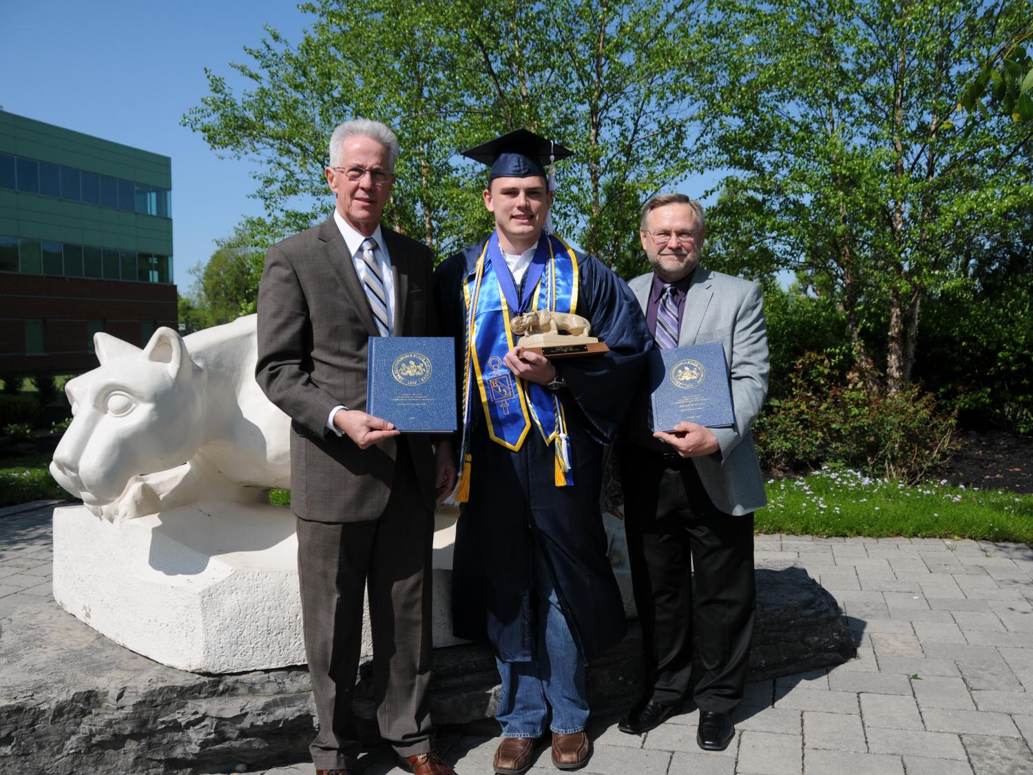 Two professors and a student pose at Lion Shrine
