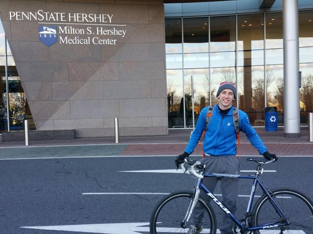 Student with his bike in front of Hershey Medical center