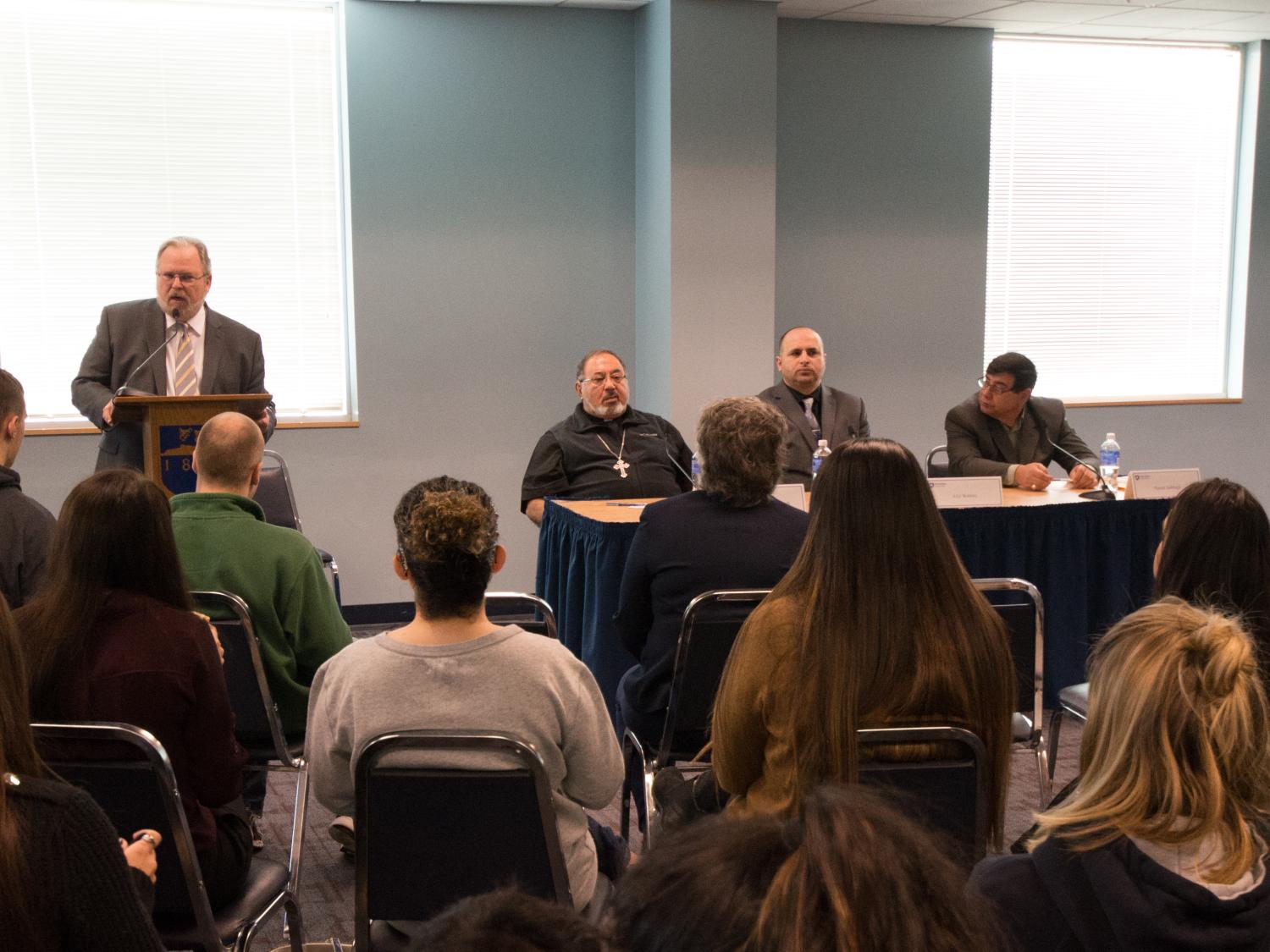 students, faculty and staff gather for a panel event