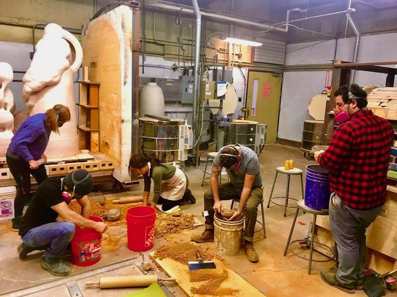 Ceramics students processing clay in studio