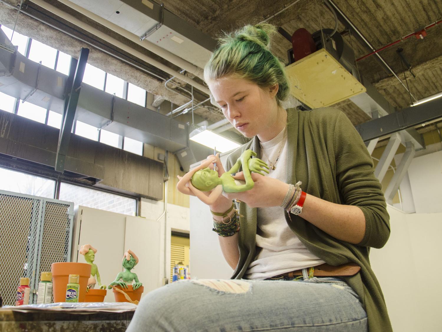 Student creating a sculpture in Art 230.