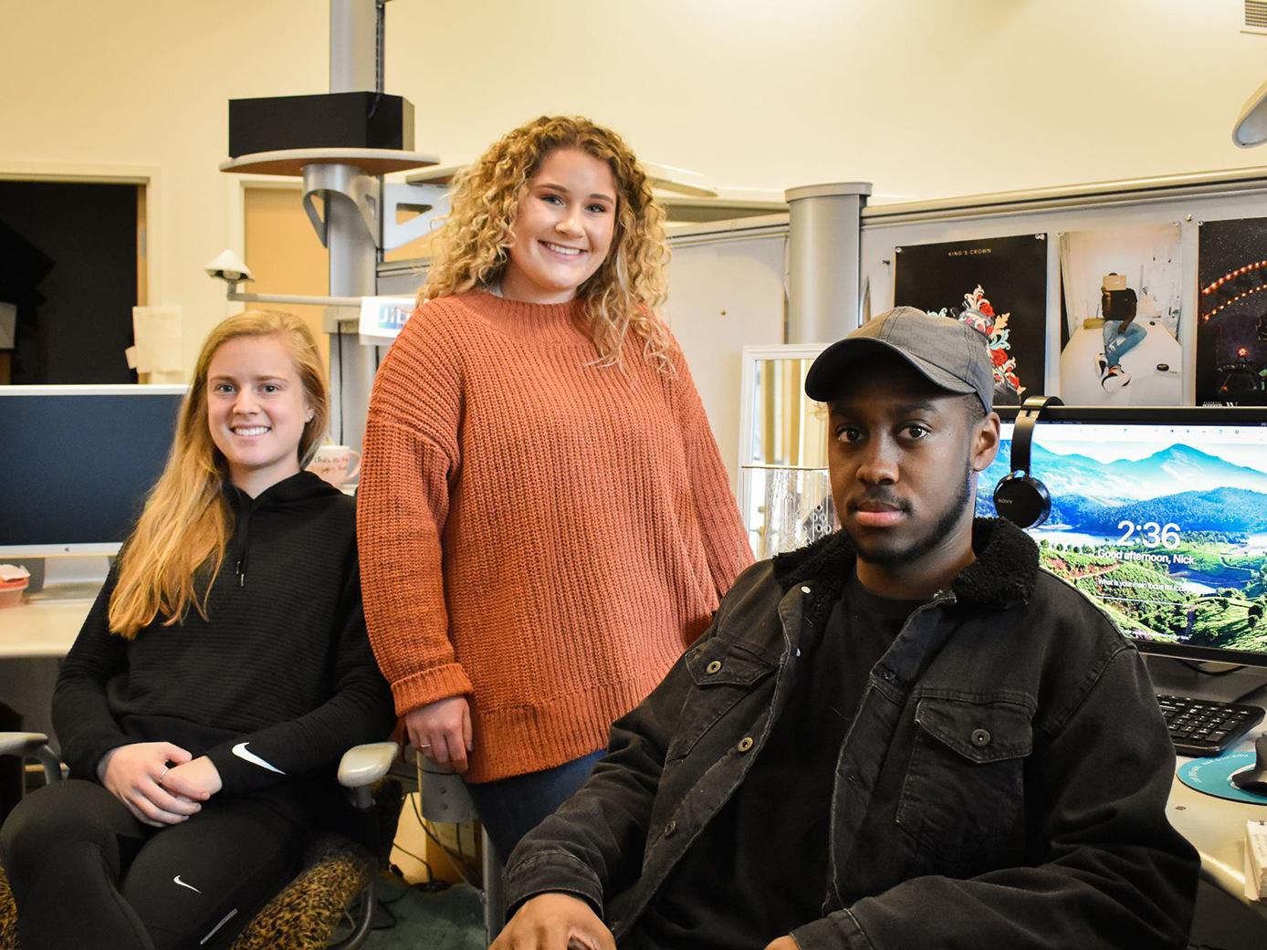 Graphic design seniors Noemie Noullet, Amelia Ball and Nick Wilson pose in the studio.