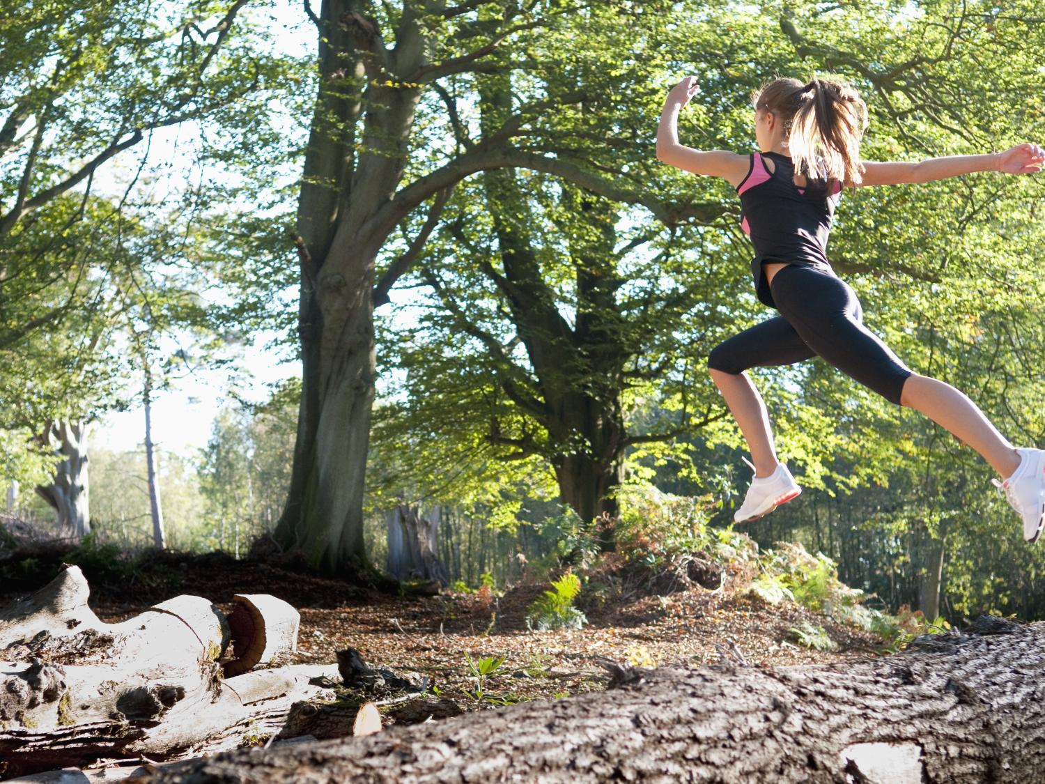 woman running on trail in woods