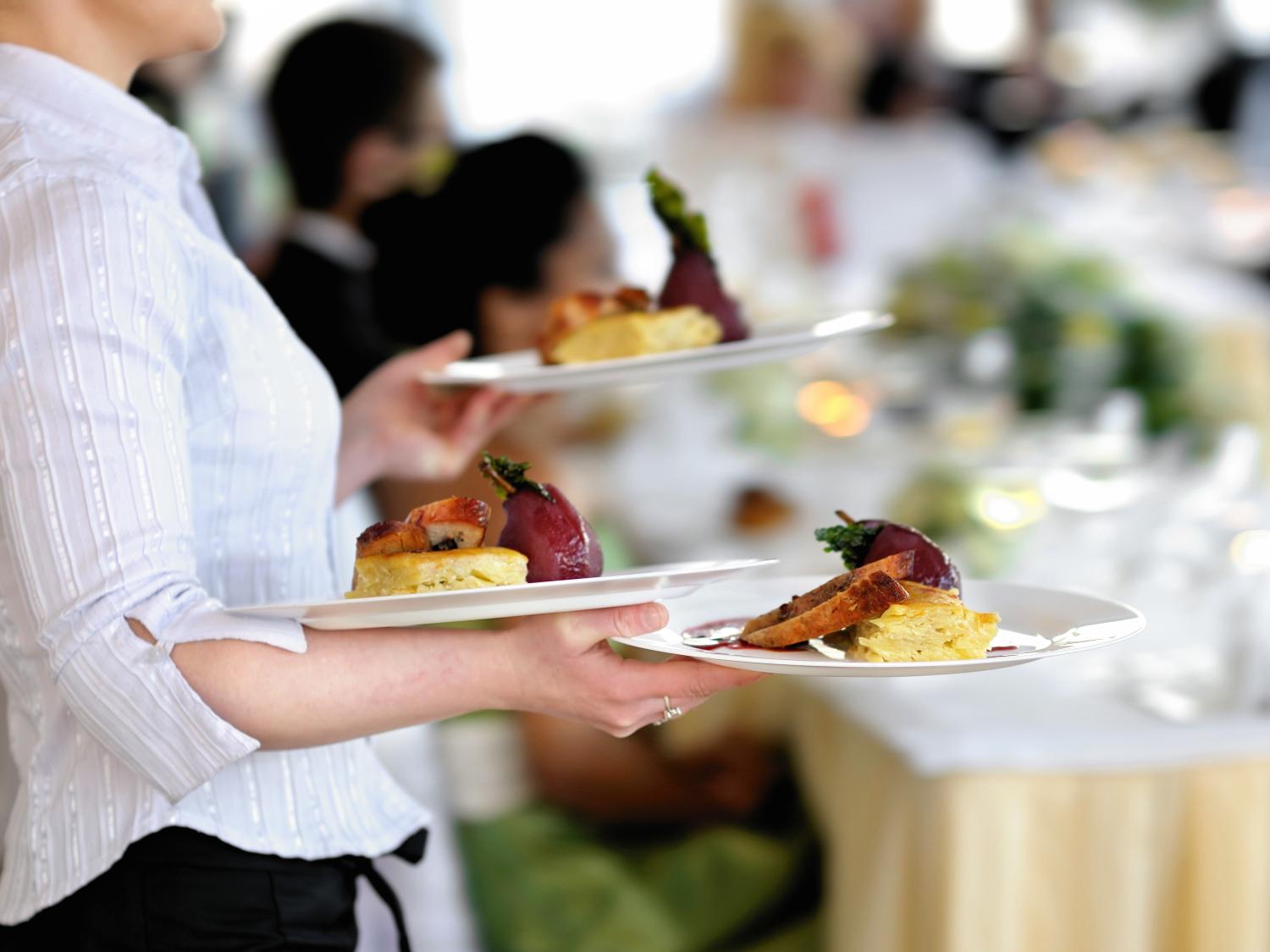 Waiter holding plates of food