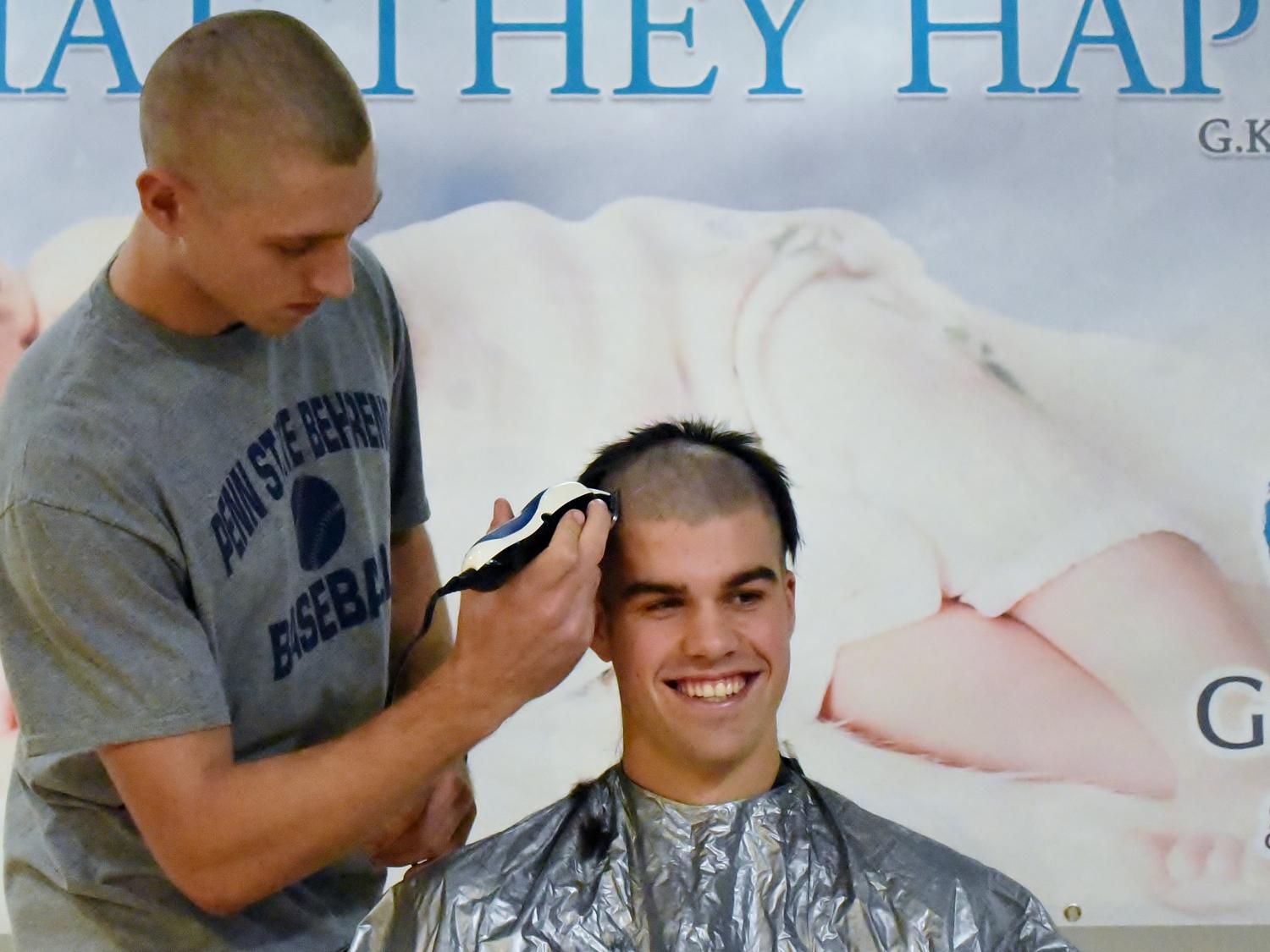 A Penn State Behrend student has his head shaved during a charity event.