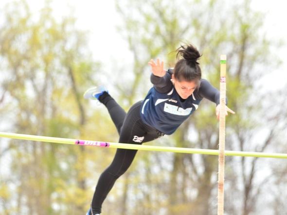 A Penn State Behrend student-athlete completes a pole vault jump.