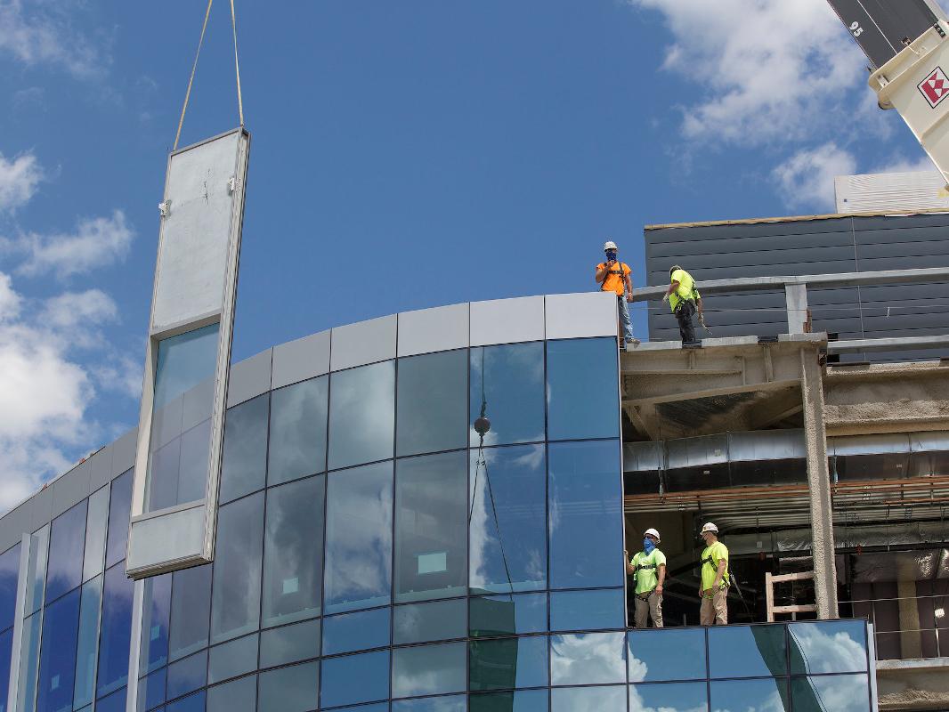 Construction crews finish an exterior wall for a hospital