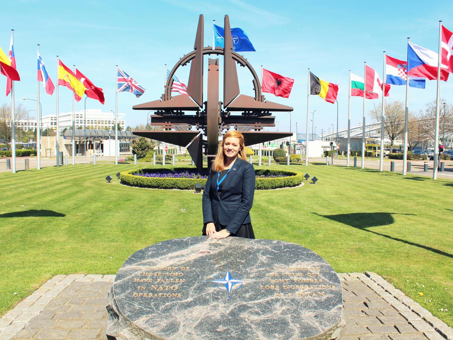 Woman and flags outside of NATO headquarters